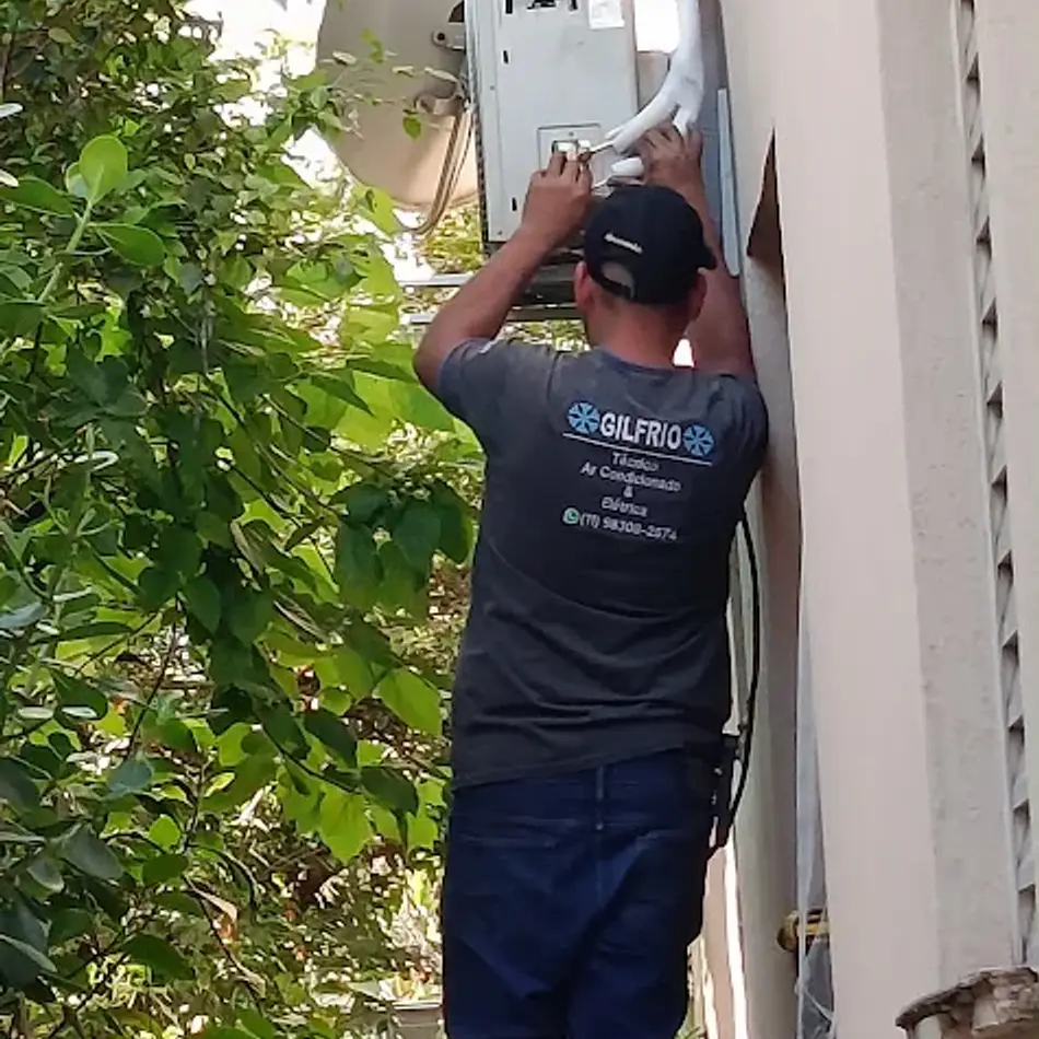 Técnico da Gilfrio atendendo uma evaporadora pela fachada do prédio